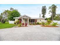 Charming single-story home featuring a well-maintained yard with gravel driveway and colorful plants at 1731 Redwood St, Sarasota, FL 34231