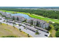 Scenic aerial view of condo community showcasing lush landscaping, a pristine lake, and a well-manicured golf course at 17510 Gawthrop Dr # 206, Bradenton, FL 34211