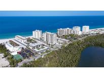 Panoramic aerial view showcases white condominium buildings on a beautiful beach with blue ocean water at 2100 Benjamin Franklin Dr # 201, Sarasota, FL 34236