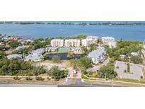 Stunning aerial view of a condo community with a lake, swimming pool, tennis courts, and beautifully landscaped grounds at 242 Hidden Bay Dr # 603, Osprey, FL 34229