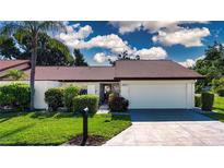 Charming single-story home featuring a lush, green lawn and well-maintained landscaping at 3843 El Poinier W Ct # 8720, Sarasota, FL 34232