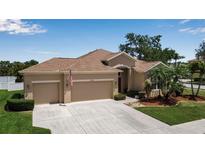 Charming single-Gathering home featuring a three-car garage, well-manicured lawn, and beautiful landscaping at 4706 Josselin Pl, Parrish, FL 34219