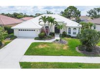 Beautiful single-story home features a white tile roof, two-car garage, and mature landscaping at 5106 Far Oak Cir, Sarasota, FL 34238