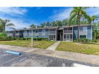 Condominium exterior with balconies, landscaping, and reserved parking under a blue sky at 5400 26Th W St # F104, Bradenton, FL 34207