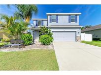 Charming two-story home with a well-manicured lawn and vibrant landscaping at 6125 35Th E Ct, Bradenton, FL 34203