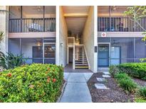 Inviting condo exterior featuring a walkway, second-story porch, and lush landscaping at 752 White Pine Tree Rd # 101, Venice, FL 34285