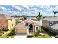 Stunning aerial view of tan house with lush landscaping and a serene waterfront backyard at 8995 Founders Cir, Palmetto, FL 34221