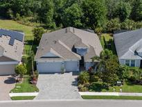 Beautiful aerial view of a well-maintained home with a three-car garage, lush landscaping, and a spacious layout at 11713 Goldenrod Ave, Bradenton, FL 34212