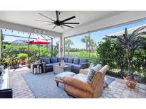 Screened lanai with comfortable seating, ceiling fan, and lush landscaping views of a pool at 12291 Myrtle Bay Ct, Sarasota, FL 34238