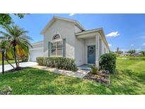 Charming single-Gathering home featuring a blue front door, well-maintained lawn, and manicured shrubbery at 12339 Hollybush Ter, Lakewood Ranch, FL 34202
