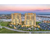 Stunning aerial view of waterfront condos with a private marina, lush landscaping, and elegant architecture at 130 Riviera Dunes Way # 903, Palmetto, FL 34221