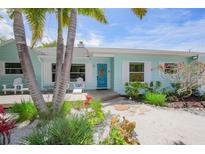Landscaped home exterior featuring a blue door, beachy foliage, and a cozy porch at 410 Garfield Dr, Sarasota, FL 34236