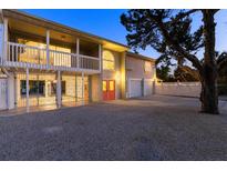 Two-story coastal home with covered balconies, three-car garage, ample parking and a red front door at 501 Key Royale Dr, Holmes Beach, FL 34217