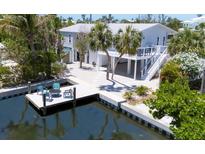 Beautifully landscaped waterfront home featuring a private dock and multi-level decking for outdoor living at 501 Key Royale Dr, Holmes Beach, FL 34217
