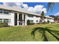 Well-maintained exterior of a two-story building with arched entryways and lush green lawn at 5800 Hollywood Blvd # 312, Sarasota, FL 34231
