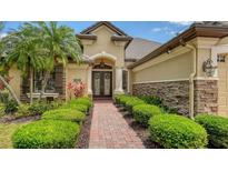 Stunning home exterior featuring a brick walkway, manicured bushes and a beautiful front entrance with double doors at 6931 Brier Creek Ct, Lakewood Ranch, FL 34202
