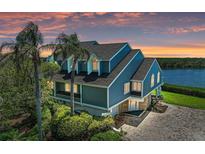 Stunning waterfront home featuring a blue exterior, a new roof, a paver driveway, and lush landscaping at 12 Tidy Island Blvd, Bradenton, FL 34210