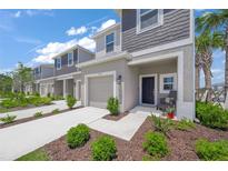 Charming townhome featuring a well-manicured lawn and an inviting front porch seating area at 15051 Ginetti St, Nokomis, FL 34275