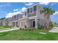 Charming two-story townhome featuring a well-manicured lawn, landscaping, and a one-car garage at 15051 Ginetti St, Nokomis, FL 34275