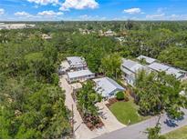 Beautiful aerial view of a home surrounded by lush trees and greenery under a sunny, blue sky at 2537 Ashton Rd, Sarasota, FL 34231