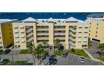 Beautiful condominium with white balconies and palm trees and beautiful water views in the background at 260 Hidden Bay Dr # 305, Osprey, FL 34229