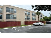 Exterior view of multi-Gathering condo with black wrought iron balconies and tan paint scheme at 2763 Woodgate Ln # 210, Sarasota, FL 34231