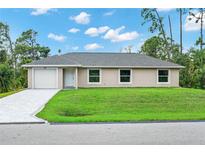 Charming single-story home with a manicured lawn, paved driveway, and neutral stucco exterior at 343 Tenk St, Port Charlotte, FL 33953