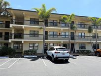 Three-story condo building featuring assigned parking and tropical landscaping at 425 30Th W Ave # C204, Bradenton, FL 34205