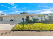 Charming single-story home with a well-manicured lawn and a two-car garage, nestled under a bright blue sky at 7311 7Th W Ave # 7311, Bradenton, FL 34209