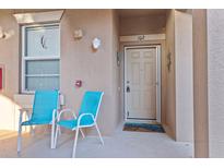 Inviting front porch featuring a pair of comfortable chairs, creating a relaxing and welcoming entrance to the condo at 803 Fairwaycove Ln # 102, Bradenton, FL 34212