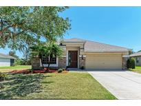 Charming single-story home featuring stone accents, manicured lawn, and a two-car garage at 9819 46Th E Ct, Parrish, FL 34219