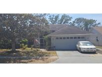 Charming single-story home featuring a two-car garage, screened porch, and mature landscaping at 5243 Sagamore Ct, New Port Richey, FL 34655