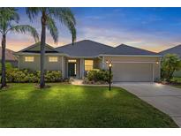 Inviting single-story home with a well-manicured lawn, mature landscaping, and a two-car garage at 12014 Beeflower Dr, Lakewood Ranch, FL 34202