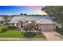 Beautiful home with a well-manicured lawn, tile roof, mature trees, and an attached two car garage at 1447 Gleneagles Dr, Venice, FL 34292