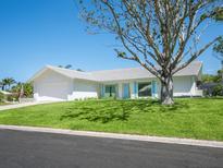 Charming single-story home with a well-manicured lawn, mature tree, and white exterior paint at 172 Sea Anchor Dr, Osprey, FL 34229
