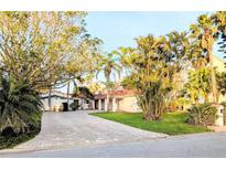 Inviting home exterior with a beautiful brick driveway and lush, mature landscaping at 173 Bath Club N Blvd, North Redington Beach, FL 33708