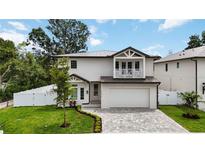 Charming two-story home with a well-manicured lawn, gray brick drive and white exterior at 2596 Floyd St, Sarasota, FL 34239