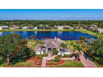 Stunning aerial view of lakeside home with mature landscaping, brick drive, and a defined property line outlined in red at 2816 88Th E Ave, Parrish, FL 34219