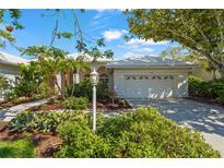 Charming single Gathering home with lush landscaping and a well-manicured lawn on a sunny day at 4180 Via Mirada, Sarasota, FL 34238