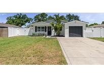 Charming single-story home featuring a well-manicured lawn, gray garage door, and beautiful curb appeal at 7141 37Th N Ave, St Petersburg, FL 33710