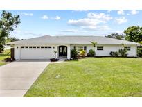 Charming single-story home boasts a well-manicured lawn, double-door entrance, and an attached two-car garage at 7912 Estates Dr, Sarasota, FL 34243