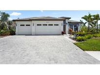 Beautiful home exterior with a three-car garage and manicured landscaping at 8229 Grande Shores Dr, Sarasota, FL 34240