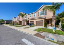 A row of tan townhouses with brown shutters and garage doors lined with palm trees, and a fire hydrant in front at 1033 Grantham Dr, Sarasota, FL 34234