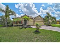 Charming single-story home with lush landscaping, brick driveway, and a three-car garage at 15608 31St E St, Parrish, FL 34219