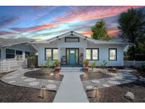 Charming bungalow showcasing a beautifully landscaped front yard and inviting entrance with rocking chairs at 1814 6Th W Ave, Bradenton, FL 34205