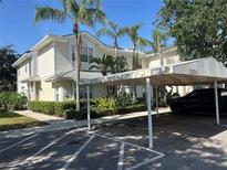 Inviting exterior showcases a tropical landscaped yard, carport, and soft yellow siding at 3405 54Th W Dr # 104, Bradenton, FL 34210