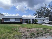 Charming single-story home with well-maintained lawn, beautiful landscaping, and a boat ready for the water at 4411 Dolphin Ln, Palmetto, FL 34221