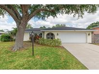 Charming single-story home featuring a well-manicured lawn and an attached two-car garage at 4415 Charing Cross Rd, Sarasota, FL 34241