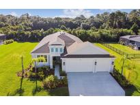 Beautifully landscaped, single-Gathering home with a manicured lawn and a two-car garage at 4515 Roycroft Ter, Parrish, FL 34219