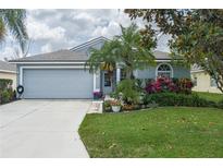Charming single-story home with a well-manicured lawn, lush landscaping, and a two-car garage at 5209 Lansdowne Way, Palmetto, FL 34221